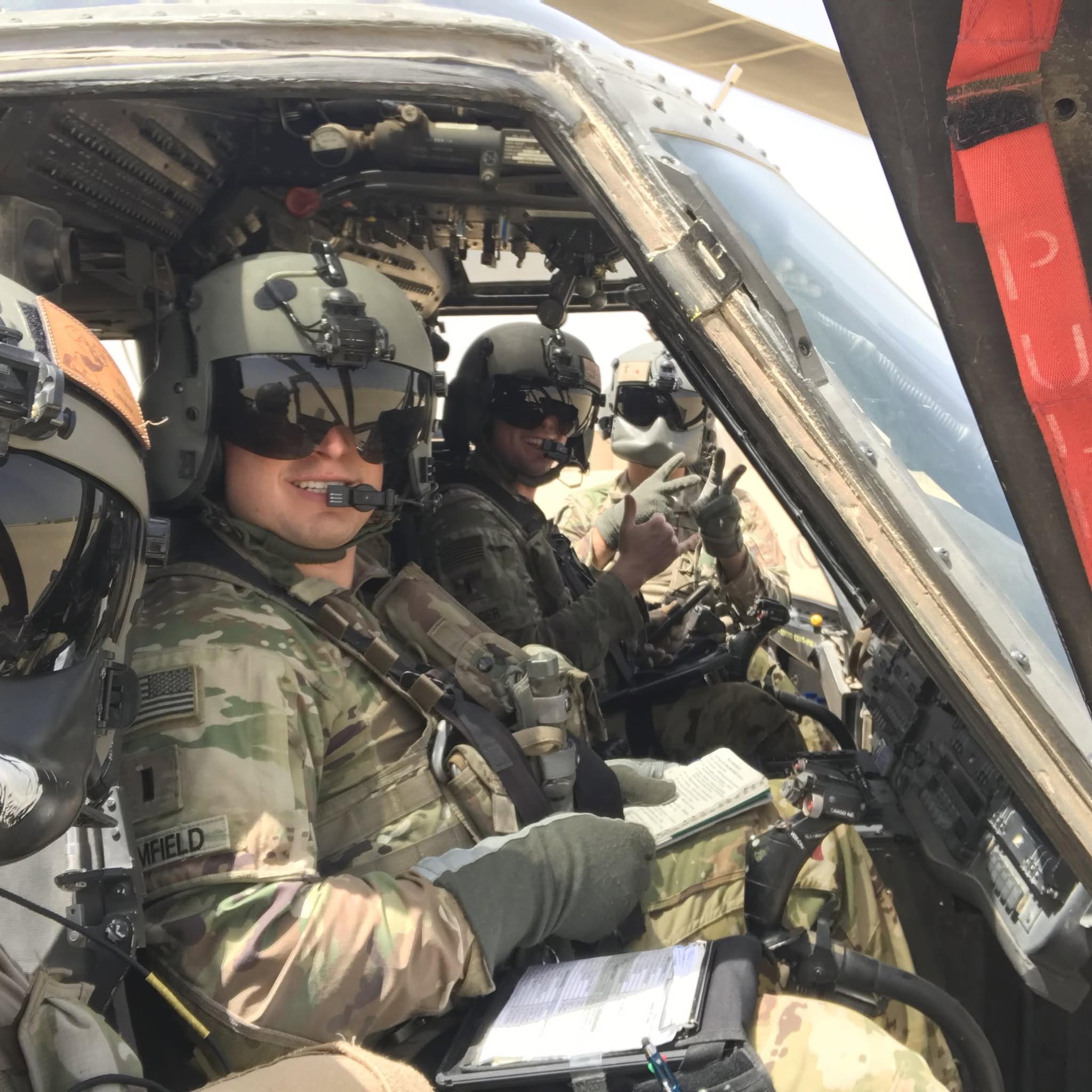 Army aviation crew wearing flight helmets in an aircraft cockpit